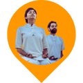 The image shows two individuals doing Bhastrika Kriya which is a powerful Kriya. They are sitting with eyes closed and palms facing upwards doing the Bhastrika Kriya. This is an inner energy process that utilizes the breath. The breath can be used as a tool to do many things with the body and the mind. Bhastrika Kriya purifies the blood, increases one’s lung capacity, and also relaxes the whole system. The combined effect allows one to breathe more easily and efficiently. Due to its particular effectiveness on the respiratory system, the Bhastrika Kriya provides relief from Asthma, Allergies & Sinusitis. It will also help with Diabetes, Hormonal Imbalance & Skin diseases.