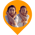 This image shows two people doing Thoppukarnam while holding the earlobes with the hands. Thoppukarnam balances the right and left sides of the brain, and at the same time exercises the body.